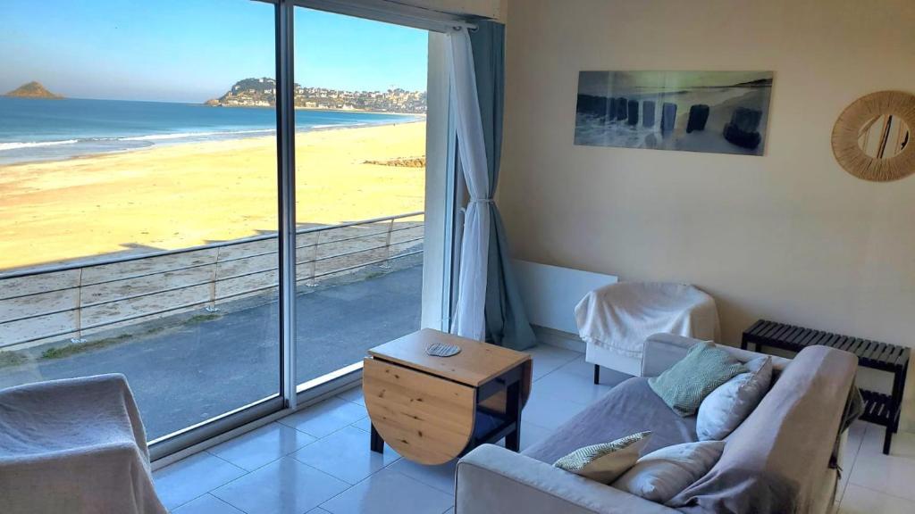 - un salon avec vue sur la plage dans l'établissement Maison pieds dans l'eau face mer, à Pléneuf-Val-André