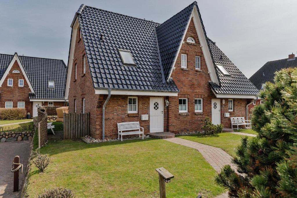 a large brick house with a large yard at Haus am Watt in Rantum