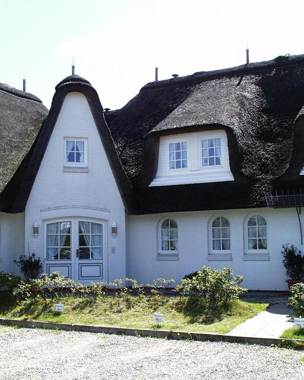 a white house with a thatched roof at Heefkant Haus Heefkant - Apartment 08 in Rantum