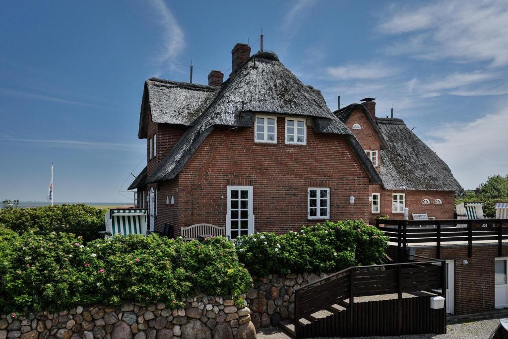 ラントゥムにあるFriesenhof, FR06の茅葺き屋根の大きなレンガ造りの家