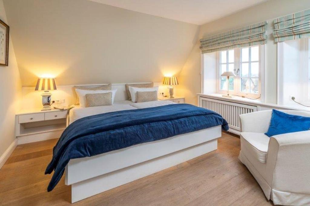 - une chambre avec un grand lit et un canapé blanc dans l'établissement Godewind Haus Godewind, GO01, à Rantum