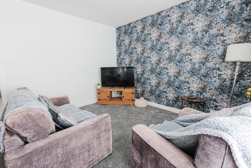 Una sala de estar con dos sofás y un televisor. en Thrush House, en Redcar