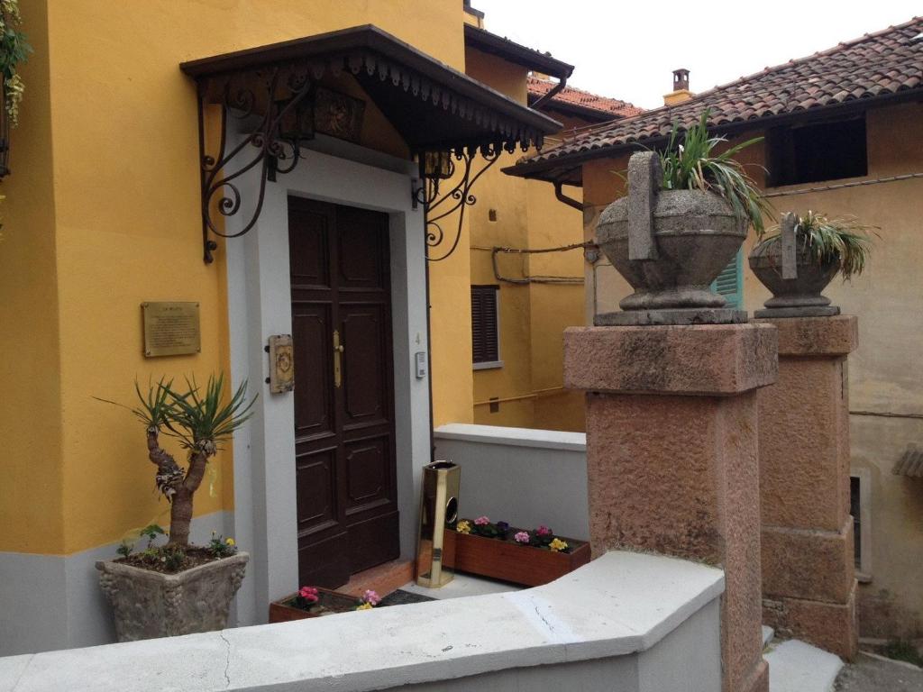 an entrance to a house with two potted plants at Foresteria Lombarda B & B Ca' Pelitti in Ganna