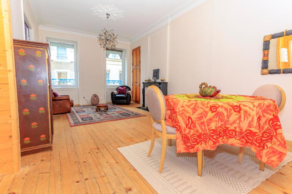 une salle à manger avec une table et des chaises dans une pièce dans l'établissement Le NID D'ORIENT, à Cherbourg en Cotentin