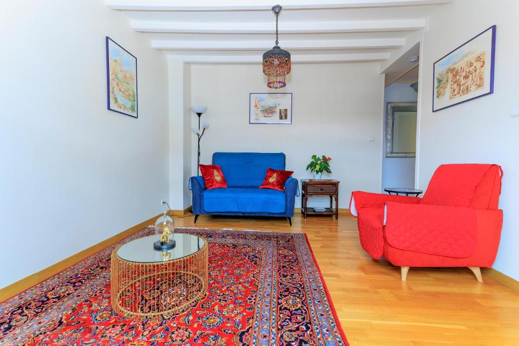 sala de estar con 2 sillas rojas y sofá azul en LE NID DES MOUETTES, en Cherbourg-en-Cotentin