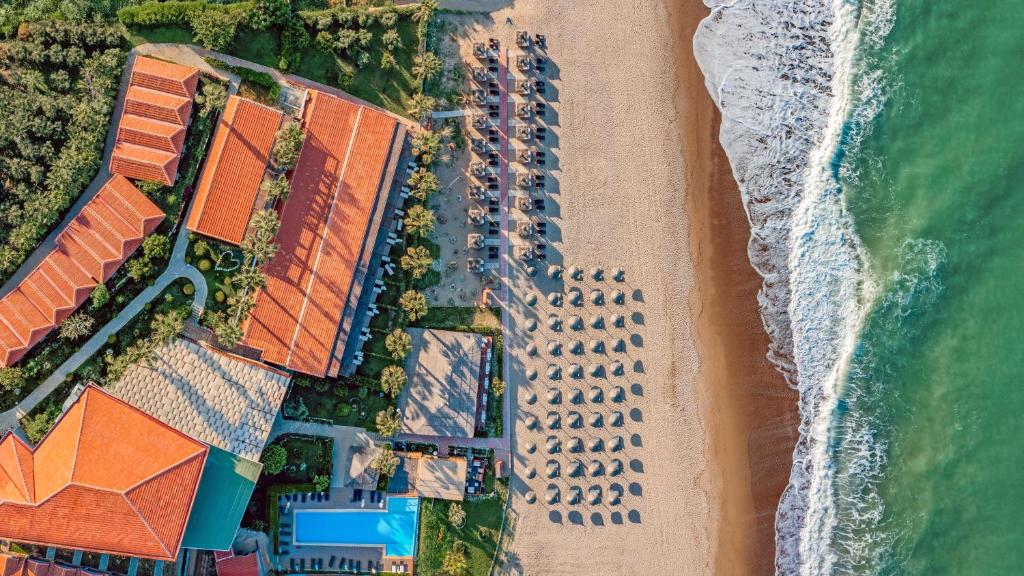 an overhead view of a beach with buildings and the ocean at Adora Calma Beach Hotel Adults Only in Kızılot