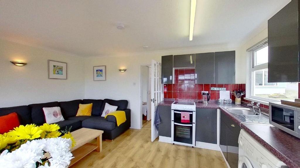 a living room with a couch and a kitchen at F40 Bayford, Riviere Towans in Hayle