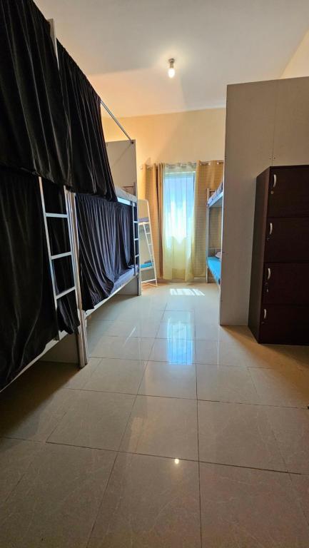 a room with bunk beds and a tiled floor at Hostel Faye in Abu Dhabi