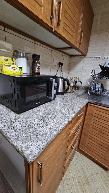 a kitchen counter with a microwave on top of it at Hostel Faye in Abu Dhabi