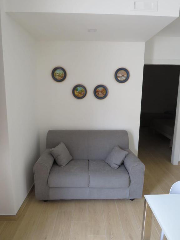 a living room with a couch and two plates on the wall at Morfeo appartamenti e camere in Palmi
