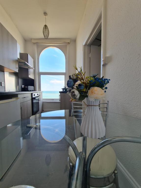 a kitchen with a glass table with a vase of flowers at Farina Holiday apartments in Bridlington