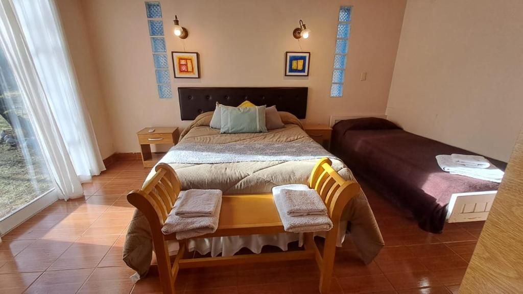a bedroom with a bed with two chairs and a table at Flor de Lis Casas de Campo in Los Cocos