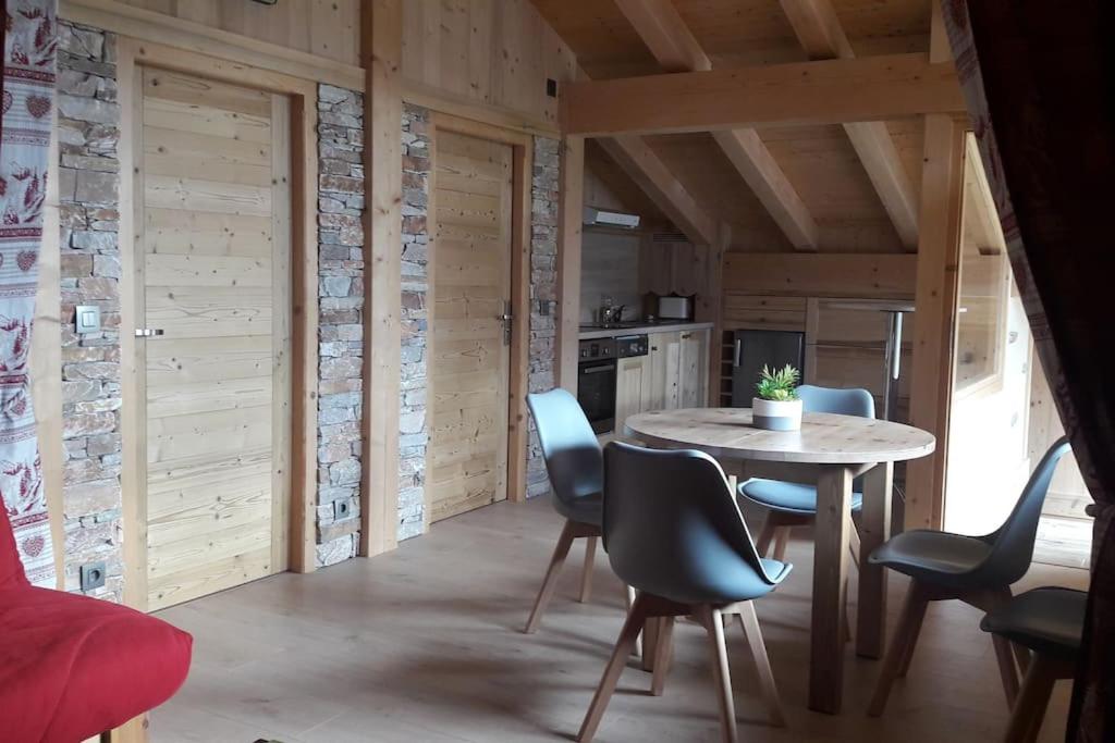 une cuisine avec une table et des chaises dans une pièce dans l'établissement Appartement sur les pistes de Megève, à Megève