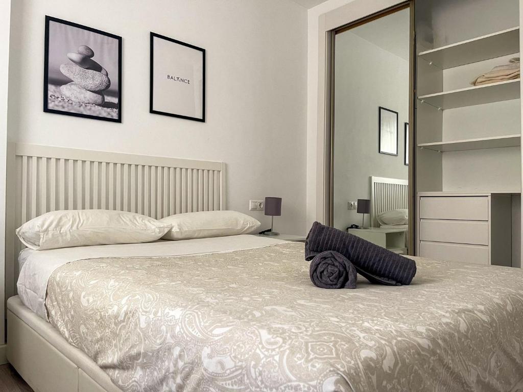 sypialnia z dużym białym łóżkiem i lustrem w obiekcie Central & Beautiful Apartment by DV Properties #P2 w Maladze