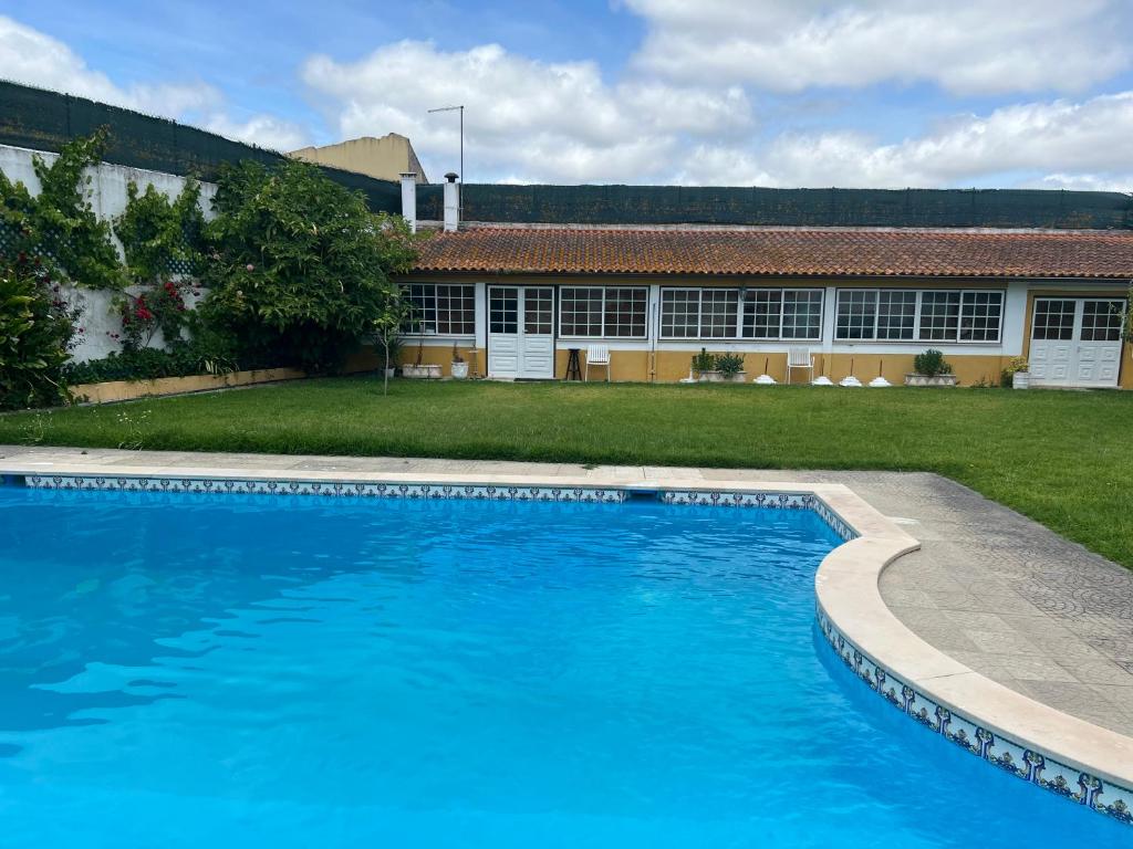 a large blue swimming pool in front of a building at Villa Cartaxense in Cartaxo