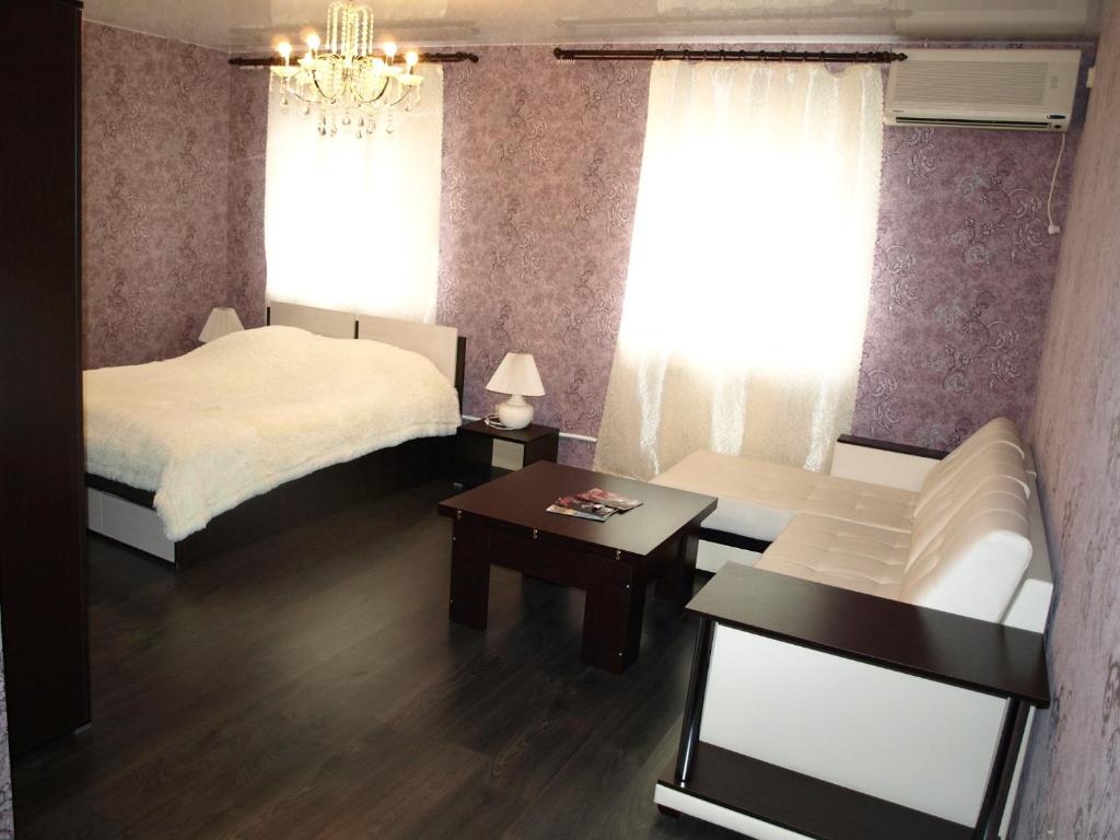 a bedroom with a bed and a couch and a table at Hotel Zebra in Yoshkar-Ola