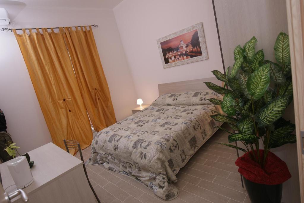 ローマにあるRooms Monteverdeのベッドルーム(ベッド1台、鉢植えの植物付)