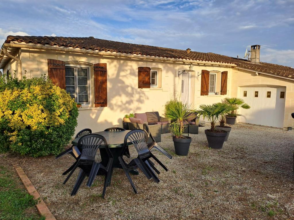 une table et des chaises devant une maison dans l'établissement L'île Verte chambre avec salle de bain privée, à Champagnac
