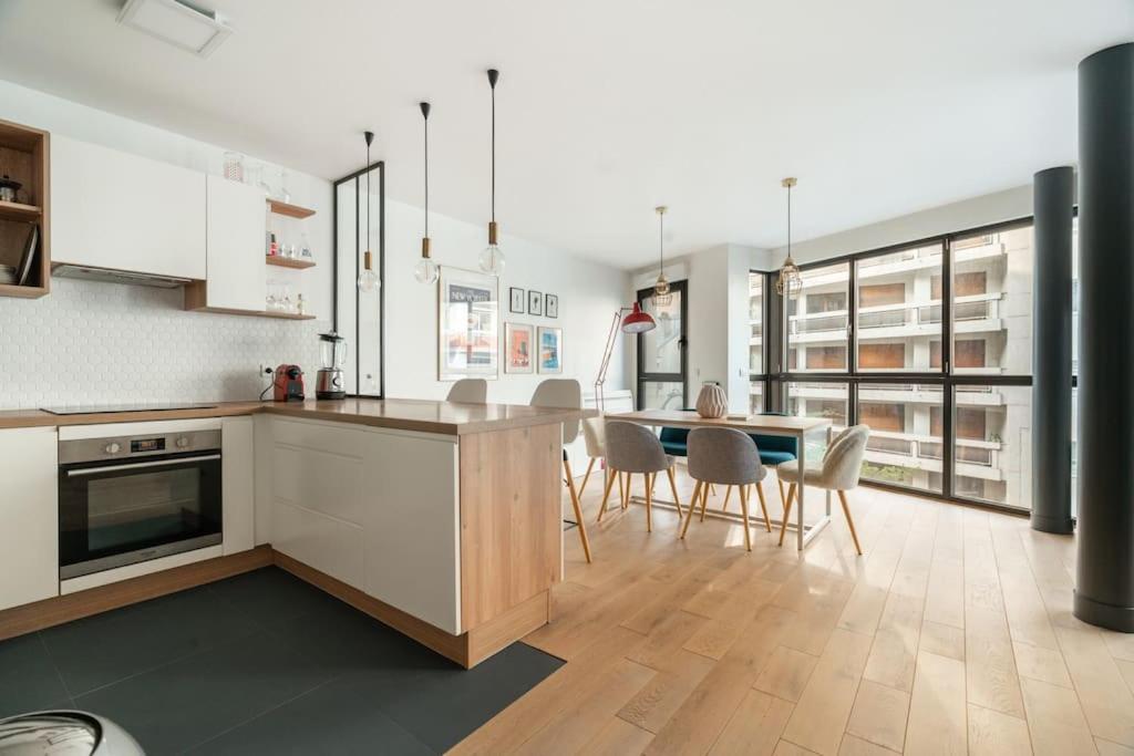 une cuisine et une salle à manger avec une table et des chaises dans l'établissement Charmant Appartement Montmartre, à Paris