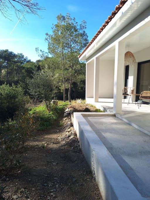 une terrasse couverte d'une maison blanche avec une terrasse. dans l'établissement Dépendance studio cosy, à Cannes-et-Clairan