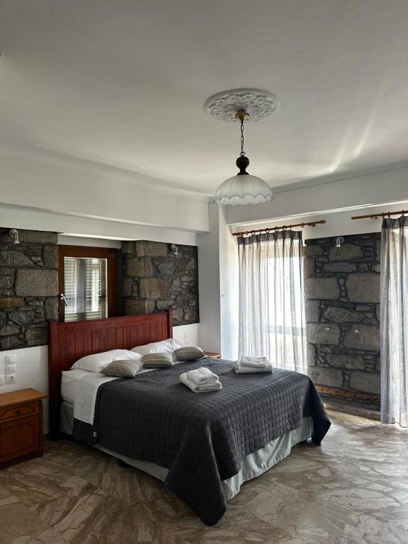 a bedroom with a bed and a stone wall at Blue Waters in Mirina