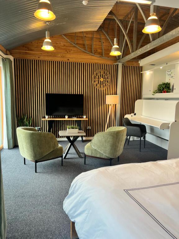 a hotel room with a bed and chairs and a television at Jackie's Place in Wexford