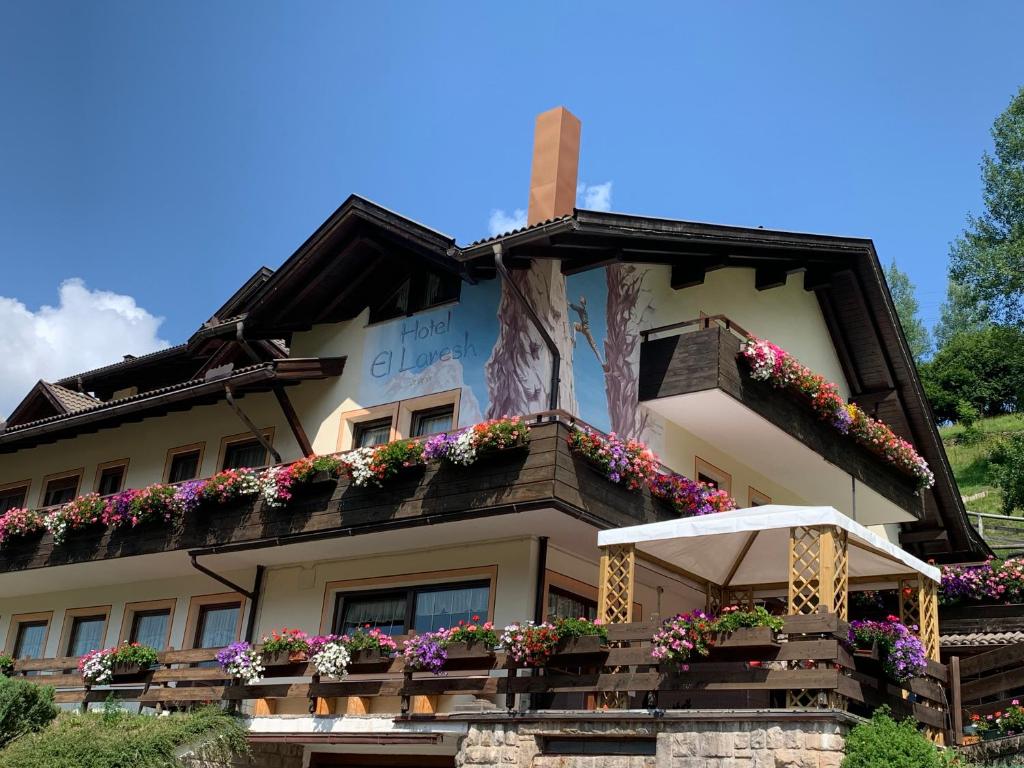 a building with flower boxes on the side of it at Hotel El Laresh in Moena