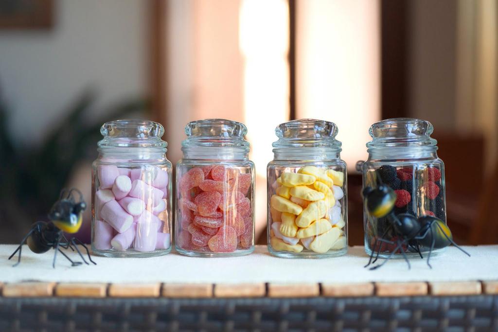 four glass jars filled with different types of candy at Hotel Albaida Nature in Mazagón