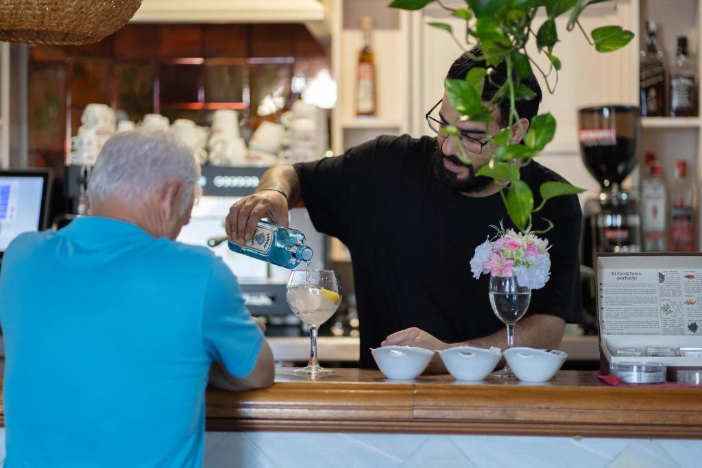 a man pouring a glass of wine at a bar at Hotel Albaida Nature in Mazagón