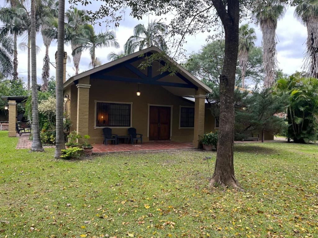 a small yellow house with a porch and a tree at La Arboleda in Corrientes