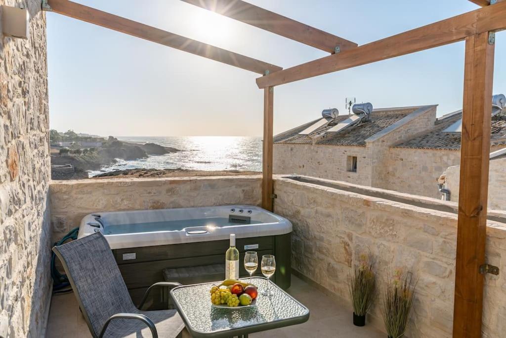 a patio with a grill and a table with a bowl of fruit at Armonia Suite in Panormos Rethymno