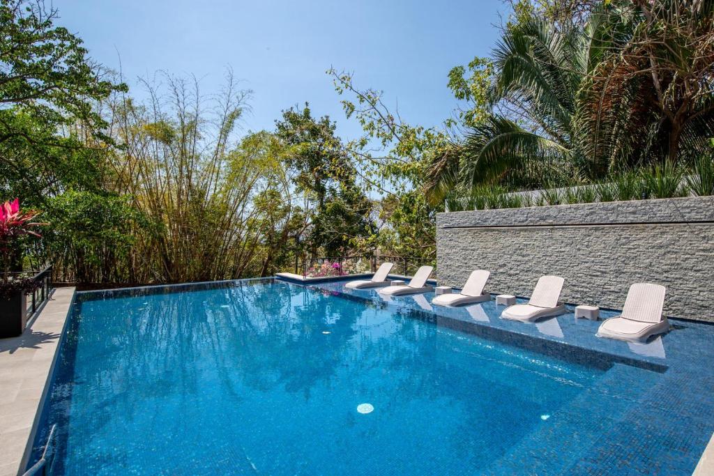 a swimming pool with a bunch of chairs in it at Ocean-View Backdrop and Private BBQ, Upscale 2 BR in Puerto Vallarta