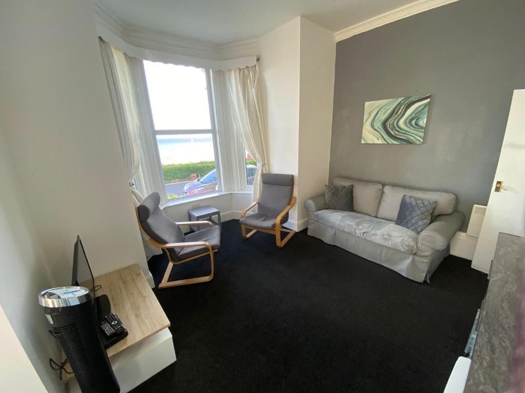 a living room with a couch and chairs and a window at Farina No2, Sea view apartment sleeping 4 guests in Bridlington