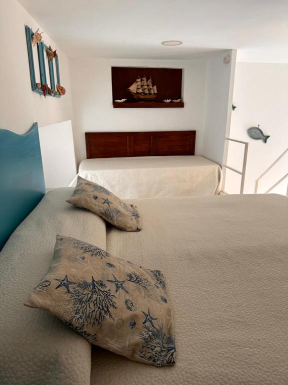 a bedroom with two beds and a couch with pillows at La Bella Annacapri in Anacapri