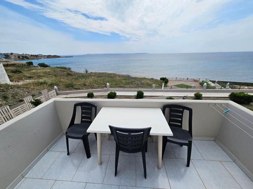 a table and chairs on a balcony with the ocean at Platsa Studios in Megás Limniónas