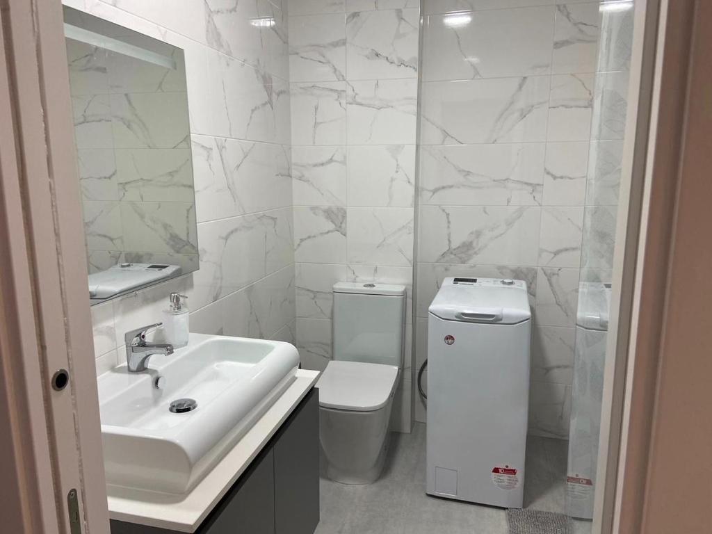 a white bathroom with a sink and a toilet at Casa Dalia - One bedroom flat in Torremolinos