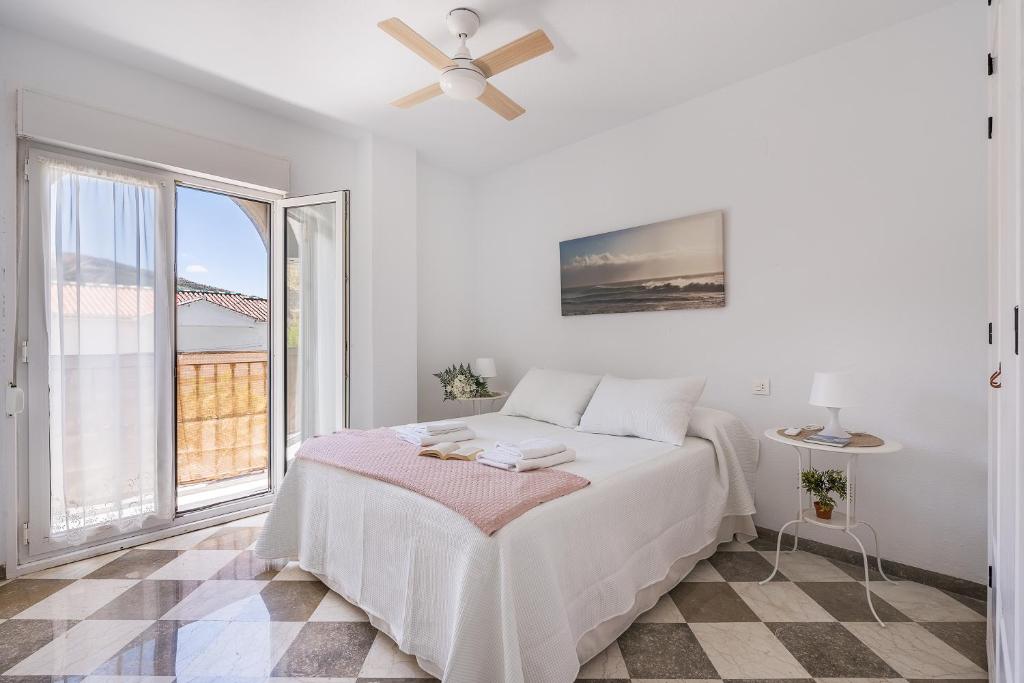 a white bedroom with a bed and a window at Rincón de Lucia Cenes de la Vega in Cenes de la Vega