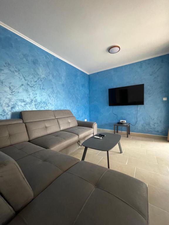 a living room with a couch and a flat screen tv at Apartment Tramontana - Konoba More in Pržno