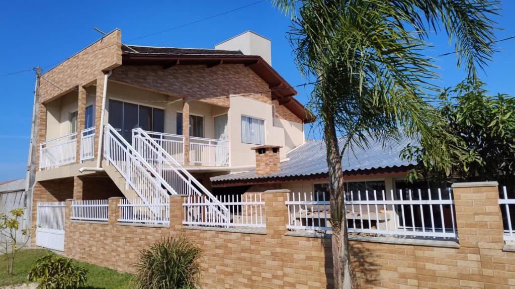 una casa con balcone su un muro di mattoni di Praia do Ervino SC a São Francisco do Sul
