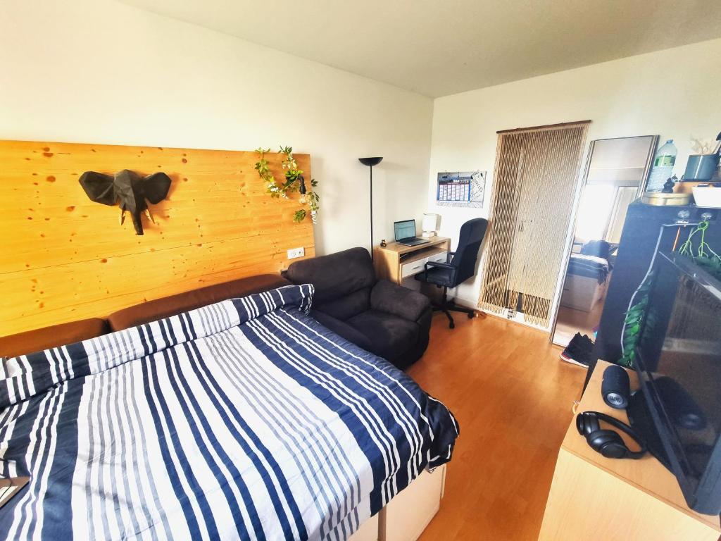 une chambre avec un lit, un canapé et un bureau dans l'établissement Chambre indépendante avec douĉhe italienne privée, à Sartrouville