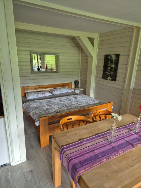 ein Schlafzimmer mit einem Bett und einem Tisch und Stühlen in der Unterkunft Ferienwohnung mit Pfiff in Siegsdorf