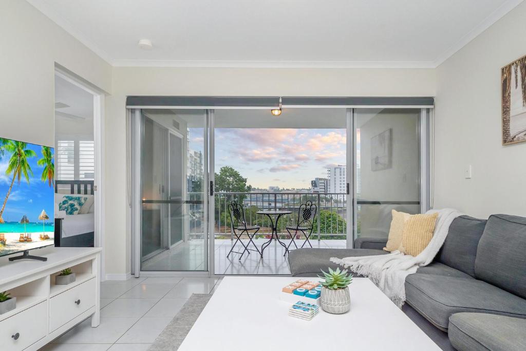 a living room with a couch and a balcony at City Love Affair On Stanley in Townsville