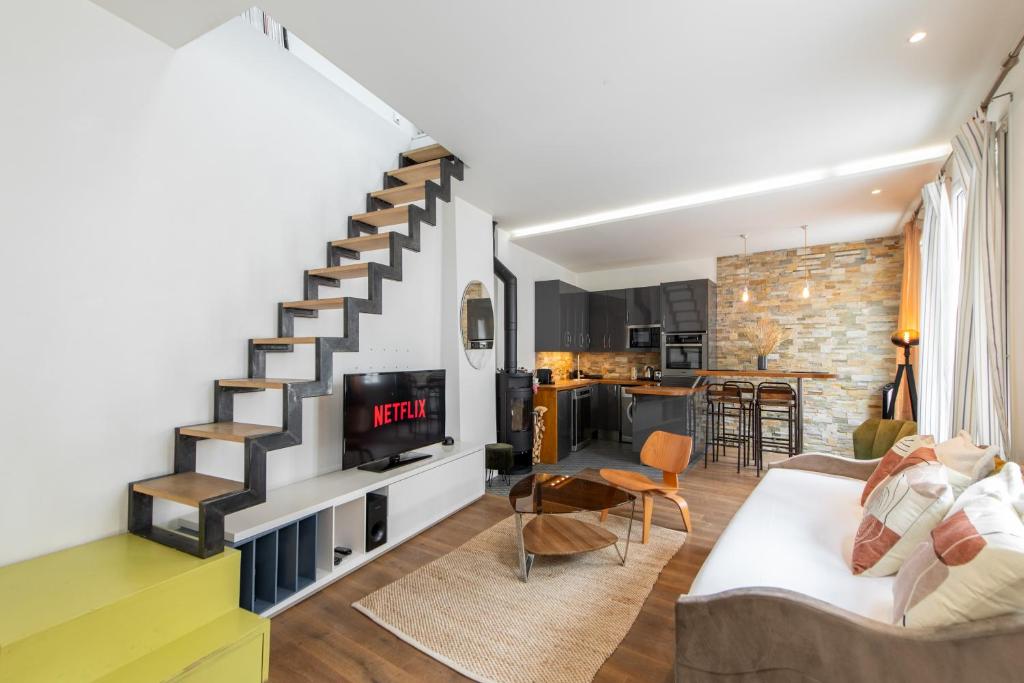 - un salon avec un escalier et une télévision dans l'établissement Amazing loft in the vibrant area near the famous Bastille's Place, à Paris