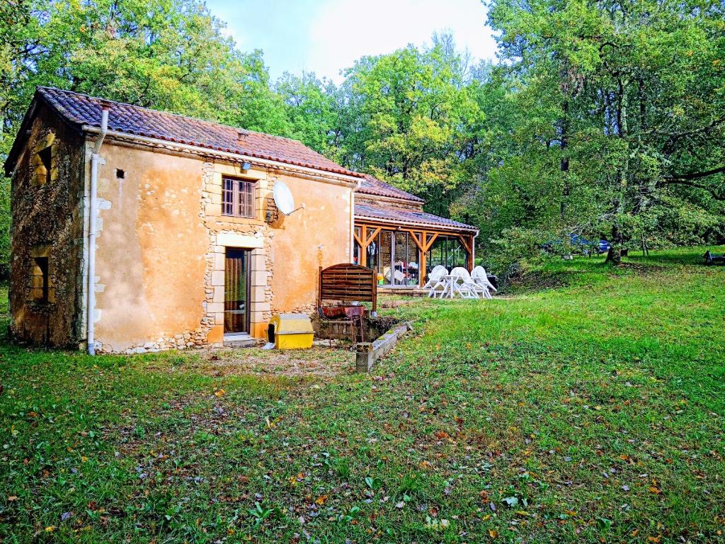 une vieille maison dans un champ avec un groupe d'animaux dans l'établissement home, à Lol