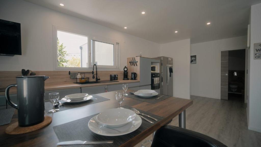 une cuisine avec une table en bois et des plaques de cuisson. dans l'établissement Belle Villa Contemporaine 10/12 personnes, à Pont-du-Château