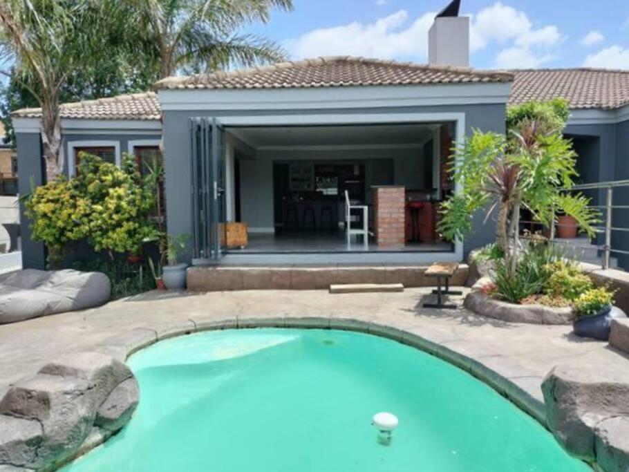 a swimming pool in front of a house at Champers with a view in Cape Town