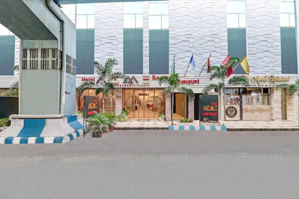 a store front of a building with palm trees at Hotel ACME in Kolkata