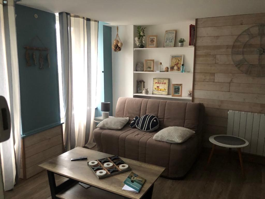 un salon avec un canapé et une table dans l'établissement La Bichetière cœur de ville, à Granville