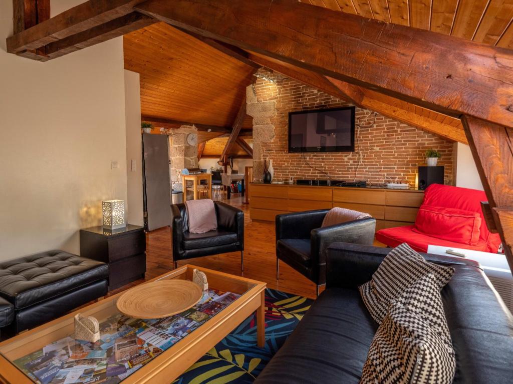 un salon avec un canapé et une télévision dans l'établissement Appartement duplex le montagne de la villa Chanterive, à La Bourboule