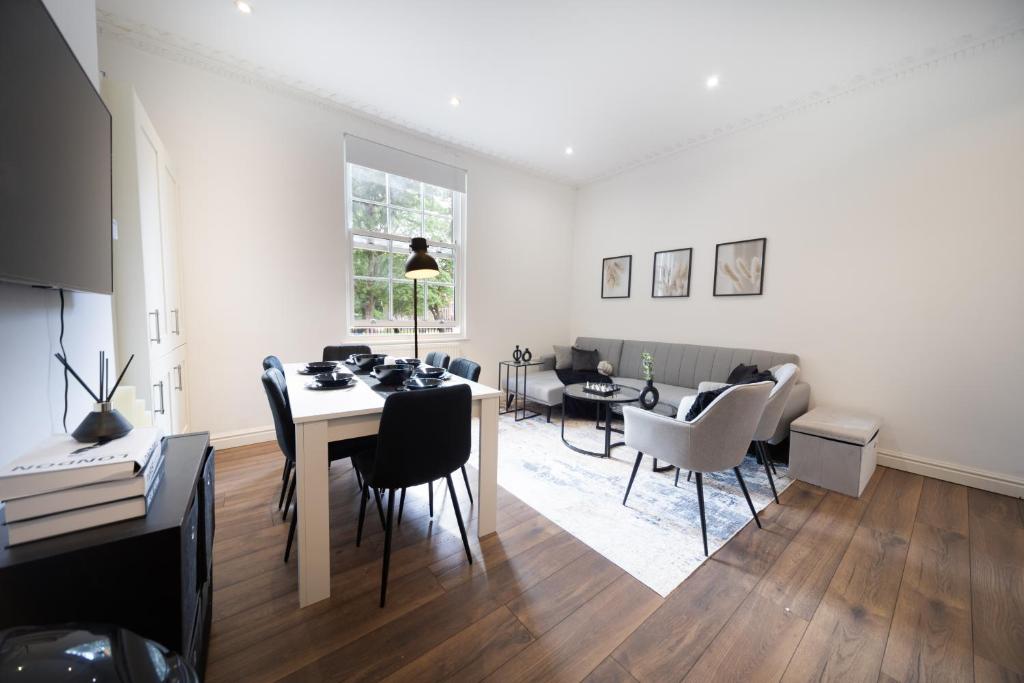 a white living room with a table and chairs at Excellent 3 bedroom, 3 baths, City Centre, voucher available in Leeds